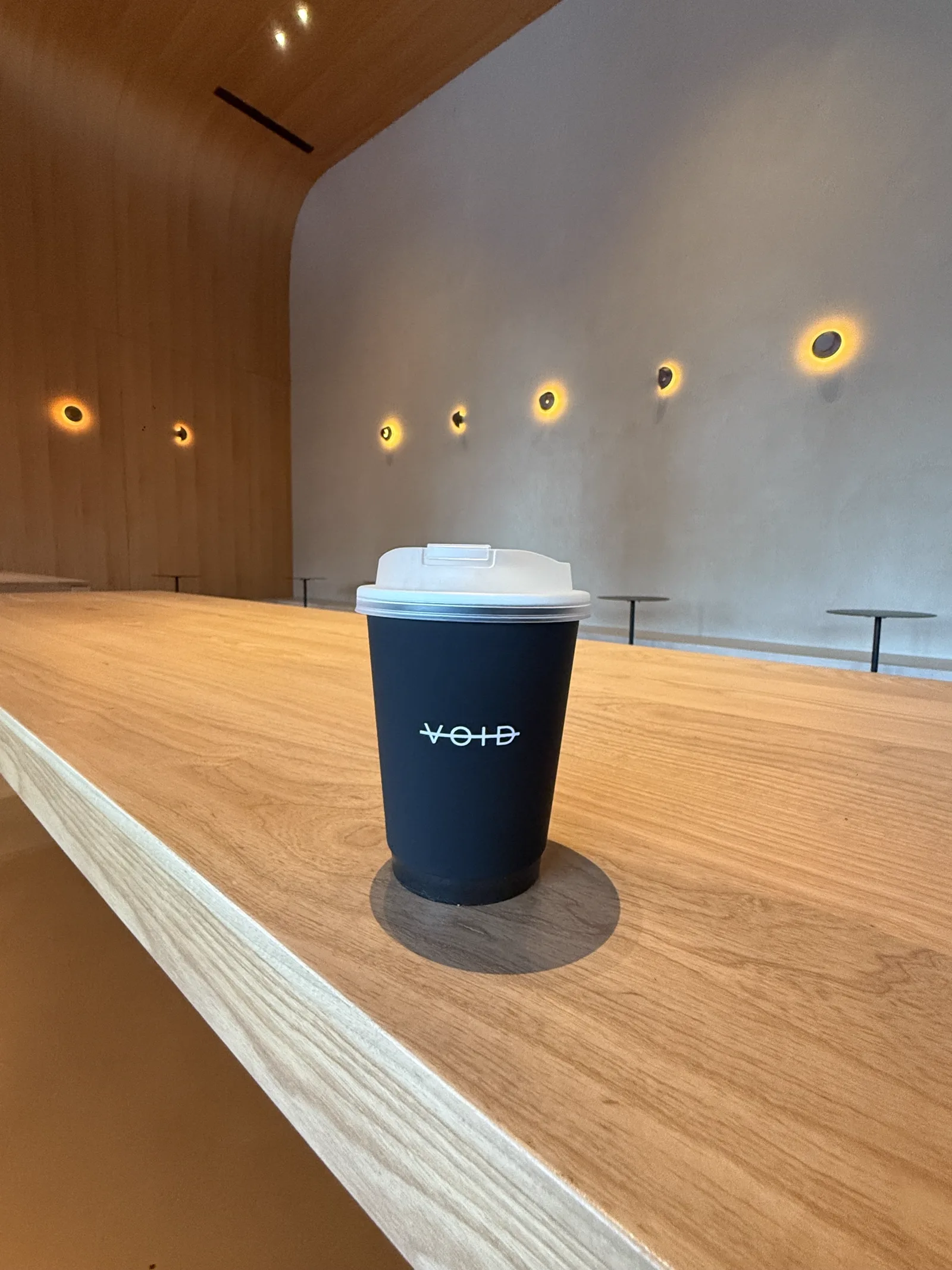 Black VOID cup on the oak counter